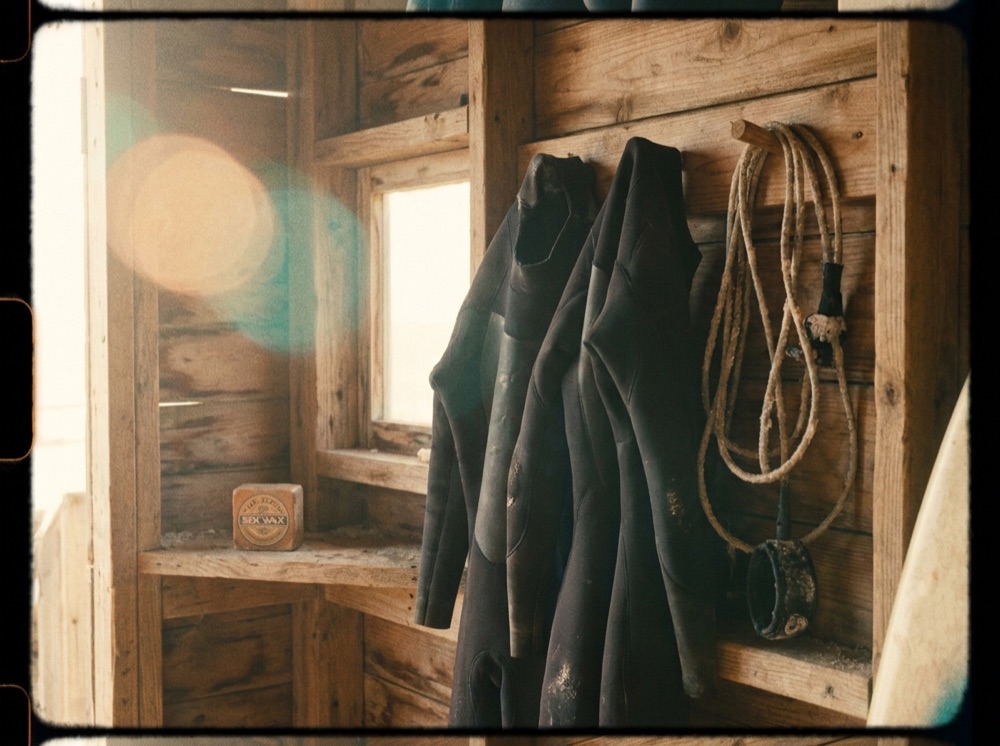 Wetsuits, leg ropes and wax hanging in the Angourie Surf Co. hire shed at golden hour